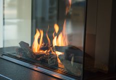 A gas fireplace with a flame burning
