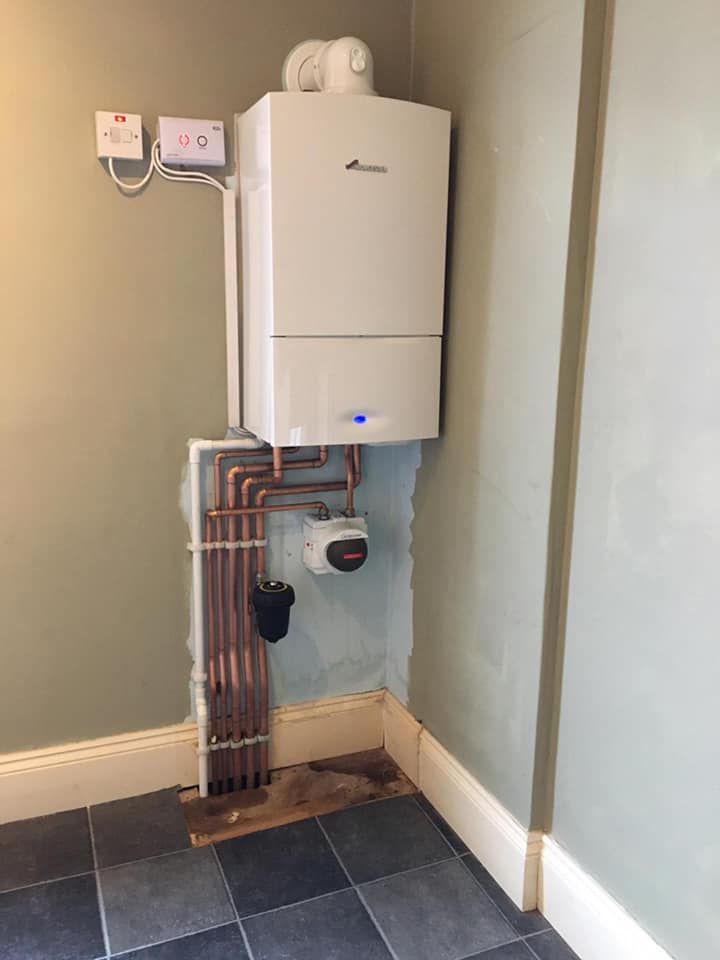 A modern white boiler in the corner of a kitchen